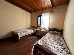 塔菲德尔瓦勒Los ciruelos - Casas de Motaña的一间卧室设有两张床,其中设有窗户。