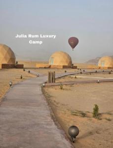 瓦迪拉姆Julia Rum Luxury Camp的飞过沙漠的热气球,有圆顶