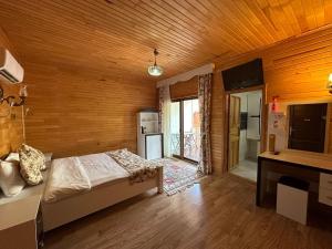契拉勒Palm Konak Hotel的一间卧室设有一张床和木墙