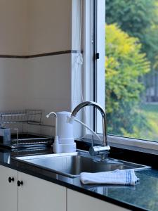 梅塞德斯Casa Country Altos Arrayanes的带水槽的厨房台面和窗户