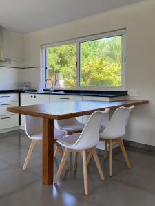 梅塞德斯Casa Country Altos Arrayanes的厨房配有木桌和白色椅子
