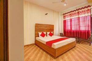 BanūrSuper OYO Hotel NR Residency的一间卧室配有床和红色窗帘