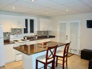 金斯顿Comfortable apartment的厨房配有带椅子和台面的岛屿