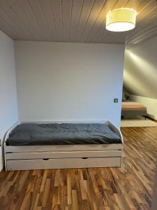 赛尼厄莱吉耶Appartement de vacances "La Poste"的一张位于木地板房间内的床