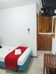 布卡拉曼加Hotel Sevilla Plaza的一间卧室配有一张床铺,床上铺有红色毯子