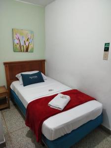 布卡拉曼加Hotel Sevilla Plaza的一间卧室配有一张带红白毯子的床