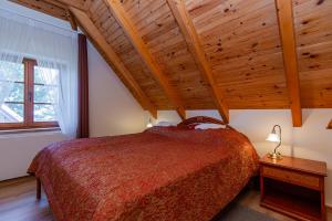 奈达维拉邦加公寓酒店的一间卧室设有一张床和木制天花板