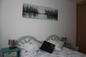 托罗Apartamento Ronda San Antón的卧室配有一张床,墙上挂着一幅画