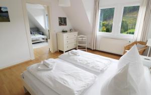 VorderfalkauFerienwohnung im Haus Rhea am Südhang- Feldberg- Falkau的一间白色卧室,配有两张床和梳妆台