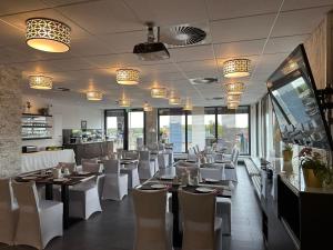 VecheldeHotel Efcannos Dornberg Carree的餐厅设有白色的椅子和桌子以及窗户。