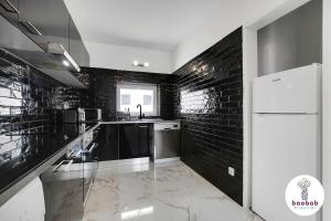 阿尔布费拉Villa Bellagio的厨房设有黑色砖墙和白色冰箱。