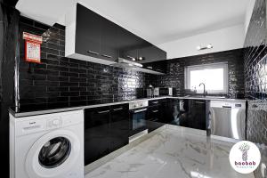 阿尔布费拉Villa Bellagio的黑白厨房配有洗衣机和烘干机