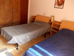 Borghettosettimana relax的客房设有两张床、一张桌子和一张书桌。