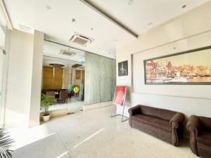 瓦拉纳西HOTEL JANHVEE INN ! VARANASI - Forɘigner's Choice ! fully Air-Conditioned hotel with Parking availability, near Kashi Vishwanath Temple, and Ganga ghat的客厅配有沙发和墙上的绘画