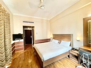 瓦拉纳西HOTEL JANHVEE INN ! VARANASI - Forɘigner's Choice ! fully Air-Conditioned hotel with Parking availability, near Kashi Vishwanath Temple, and Ganga ghat的酒店客房,配有床和电视