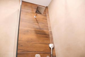 SuharekëHotel Rozafa的浴室铺有木地板,设有淋浴。