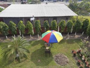 焦尔哈德Palm715 Villa in jorhat的坐在院子顶上的彩伞
