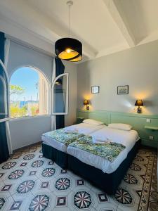 勒拉旺杜Hôtel Astria的一间卧室设有一张大床和大窗户