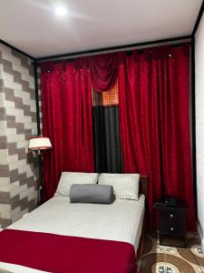里奥内格罗HOTEL PARADISE RIONEGRO的卧室配有红色窗帘和大床