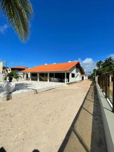 佩罗巴Casa à Beira-mar de Peroba的海滩上一座带橙色屋顶的建筑