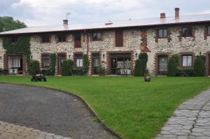 ŻarkiJurajka的一座大型砖砌建筑,前面有一片绿色草坪