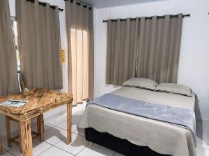 皮雷诺波利斯Pousada Sunflower的一间卧室配有一张床和一张木桌