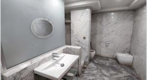 巴格达Almansour Hotel的一间带水槽、卫生间和镜子的浴室