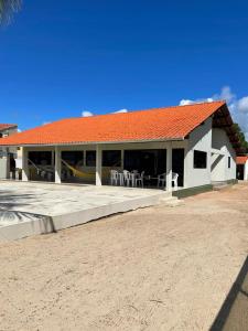 佩罗巴Casa à Beira-mar de Peroba的海滩上一座白色的建筑,屋顶橙色