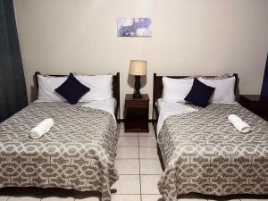 圣萨尔瓦多Hotel Sueños的卧室内两张并排的床