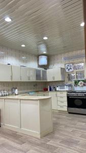 艾卜哈السحاب的厨房配有白色橱柜和黑炉。