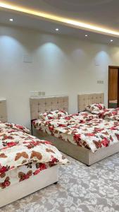 艾卜哈السحاب的配有红色和白色毯子的客房内的两张床