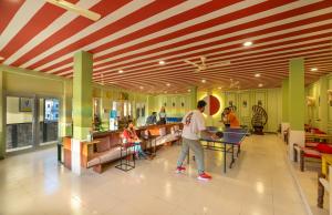 瑞诗凯诗The Hosteller Rishikesh, Ganges的在一个商场里打乒乓球的人