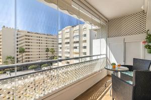 马贝拉City Center Apartment in Marbella的公寓的阳台配有桌椅。