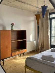 库塔伊西Black Tomato Hostel Kutaisi的一间卧室配有一张床和一个木制梳妆台