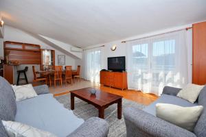 斯普利特Apartman Bačvice near the beach的带沙发、电视和桌子的客厅