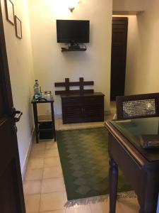 新德里Lutyens Bungalow的客厅设有壁挂式电视和桌子。