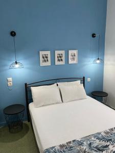卡梅纳维洛拉Thalia Hotel的一间蓝色卧室,配有一张带两张桌子的床