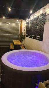 MonkwearmouthCabin of Light - Hot Tub, Sauna, Massage Chair, BBQ, Games, Beach的一个带桌子的房间里一个大紫色浴缸
