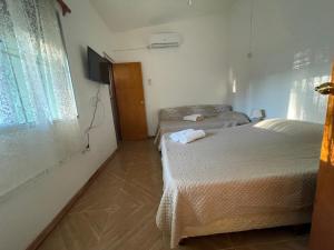 米纳斯Cómodo apartamento en Minas, con amplio fondo y entrada para vehículo的一间卧室配有两张床和电视。