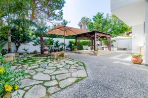 加利波利Baia Verde - Summer Rooms的一个带长凳和遮阳伞的庭院