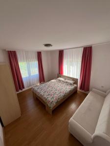 LjubovijaVikendica Lazic的一间卧室配有一张床、一张沙发和窗户。