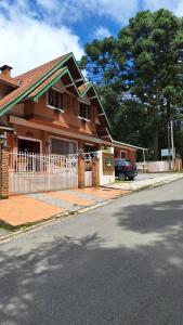 坎波斯杜若尔当Pousada Atalaia Capivari的街上的棕色房子,有白色的围栏