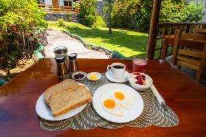 阿约拉港La Peregrina Galapagos B&B的木桌上的鸡蛋和烤面包早餐
