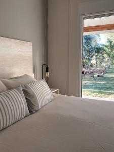 梅塞德斯Casa Country Altos Arrayanes的卧室配有白色的床和大窗户