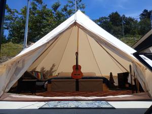 蒙泰韦尔德哥斯达黎加Better Life Mountain Camp Monte Verde的白色帐篷内有吉他