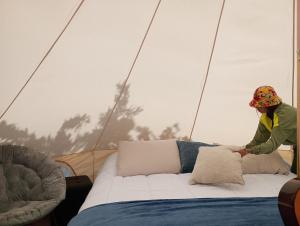 蒙泰韦尔德哥斯达黎加Better Life Mountain Camp Monte Verde的坐在帐篷里的床上的女人