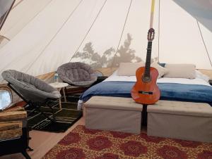 蒙泰韦尔德哥斯达黎加Better Life Mountain Camp Monte Verde的帐篷内的卧室配有吉他