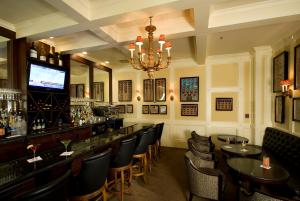 旧金山玛吉斯迪克酒店的酒吧配有桌椅和吊灯