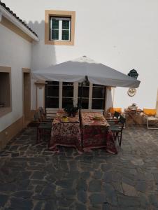 马尔旺Casa Do Ginjal by NaturAlegre的露台上的桌子和遮阳伞