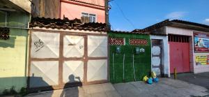 新伊瓜苏Kitinet aconchegante em Nova Iguaçu的一座建筑,设有绿色和白色的车库,并有一扇门